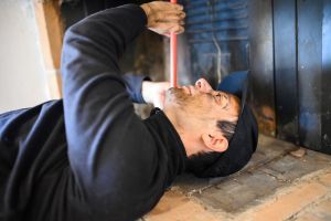 chimney sweep performing fireplace maintenance