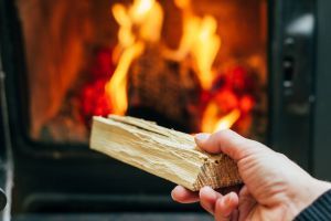 putting a log into a wood burning stove